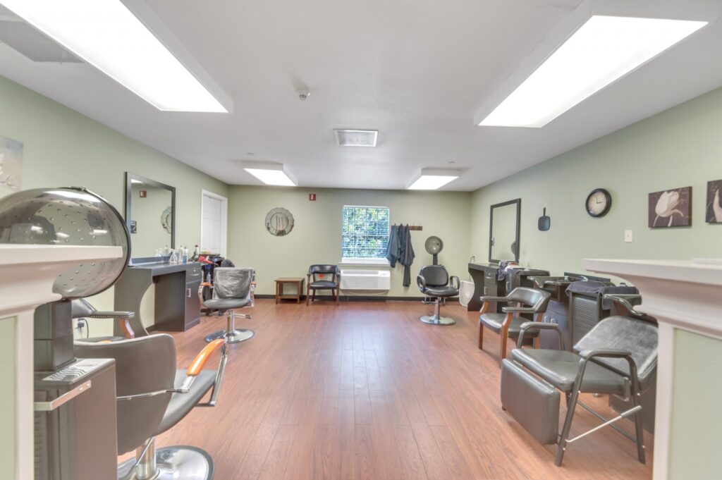 DSC_5018 - Collier Park A full-service salon with professional styling chairs, wash stations, and a hair dryer at Collier Park, offering senior living near Lake Charles, LA.