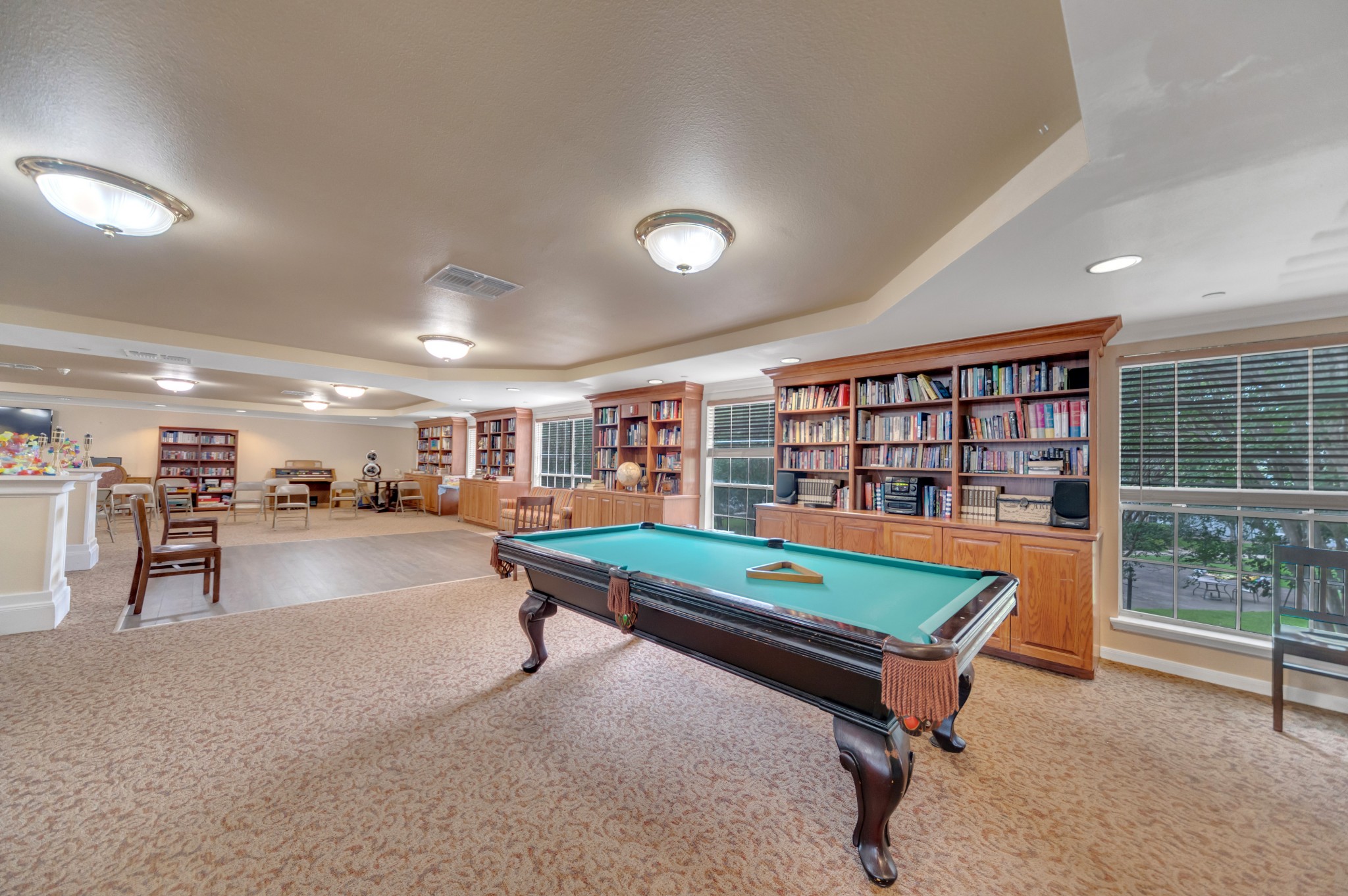 DSC_5069-1 - Collier Park Interior shot of Collier Park's recreation room with lots of bookcases, a pool table, a dance floor, and more.
